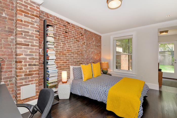 Picture of a photograph showing an exposed brick bedroom