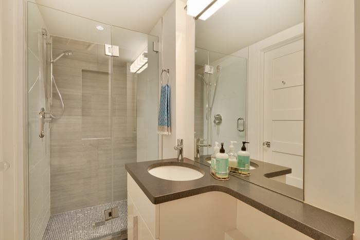 Photograph showing a small bathroom with a large mirror